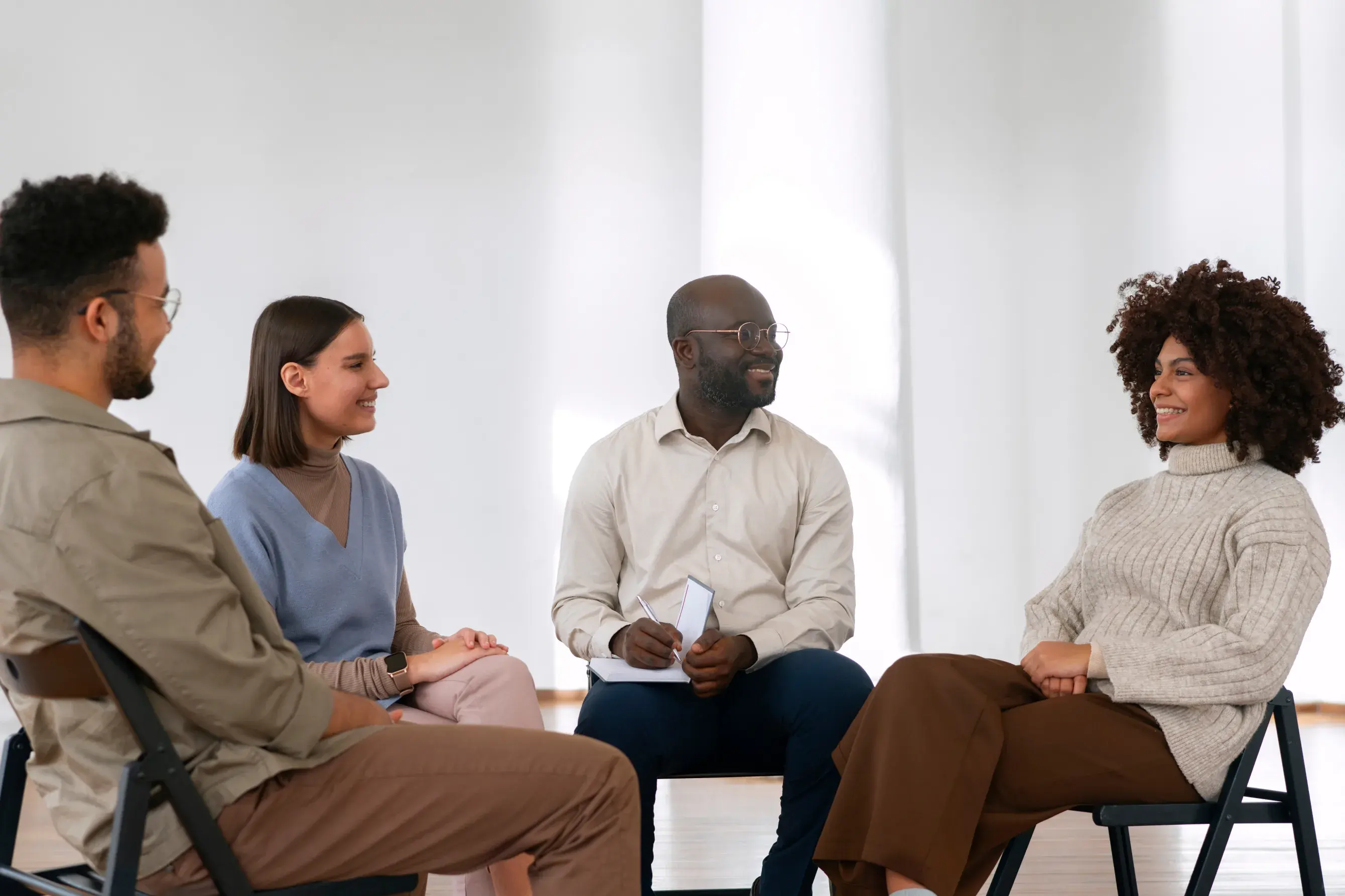 A small group sitting in a circle, talking and laughing