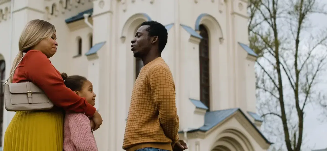 A family talking with a young man outside a church